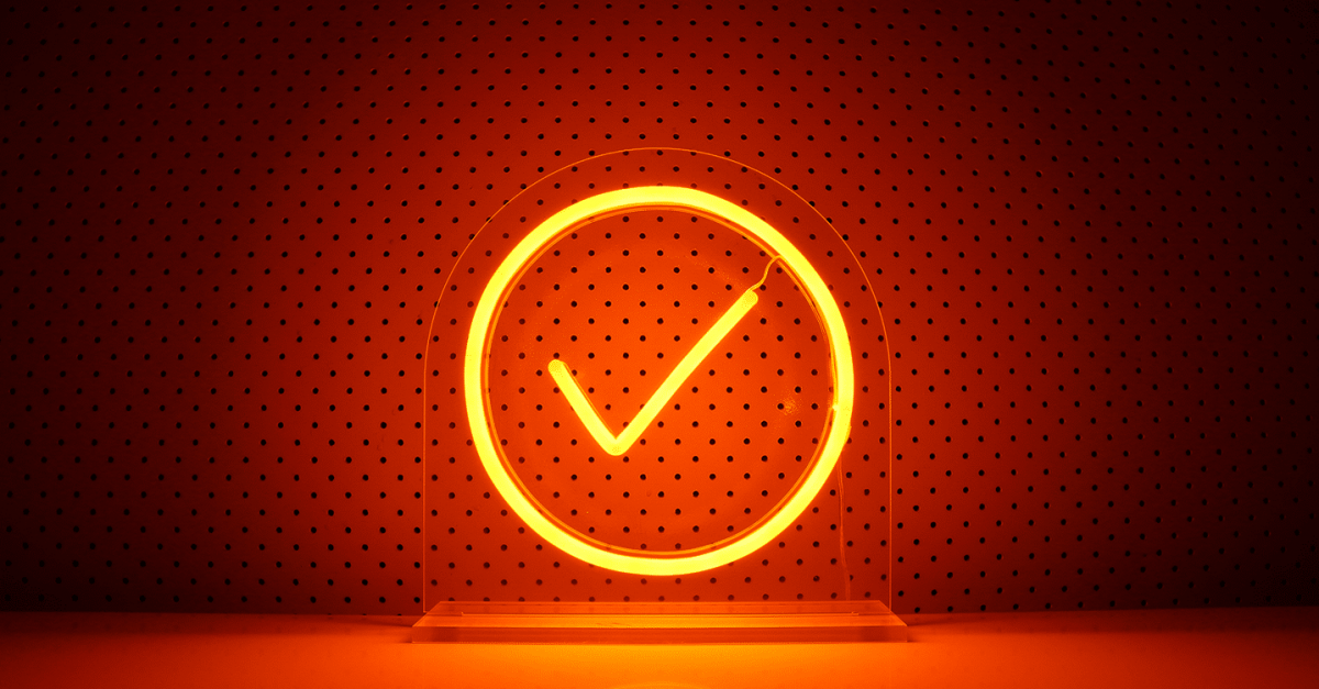 A photo of a lit up orange neon Admin By Request sign with a dotted background.