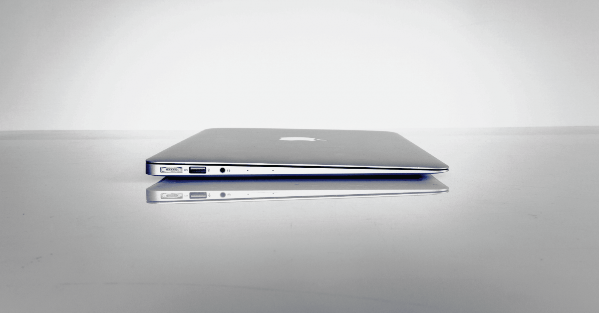 A closed MacBook Air with a white and grey background.